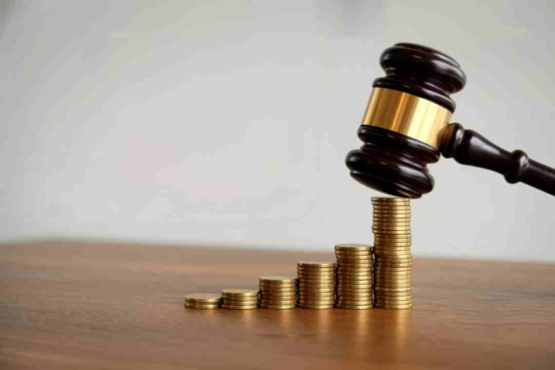 Gavel on stacks of coins representing financial law.